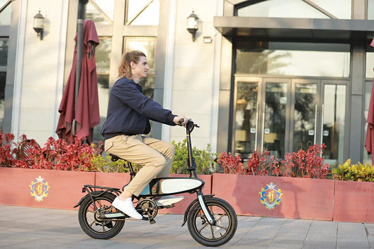 Side lifestyle shot of man riding compact white DYU C2 foldable electric bike on modern building plaza.