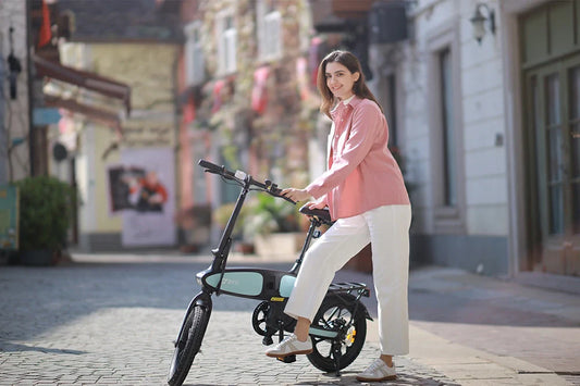 DYU C2 foldable e-bike with mint-green accents, woman preparing to ride on a cobblestone street